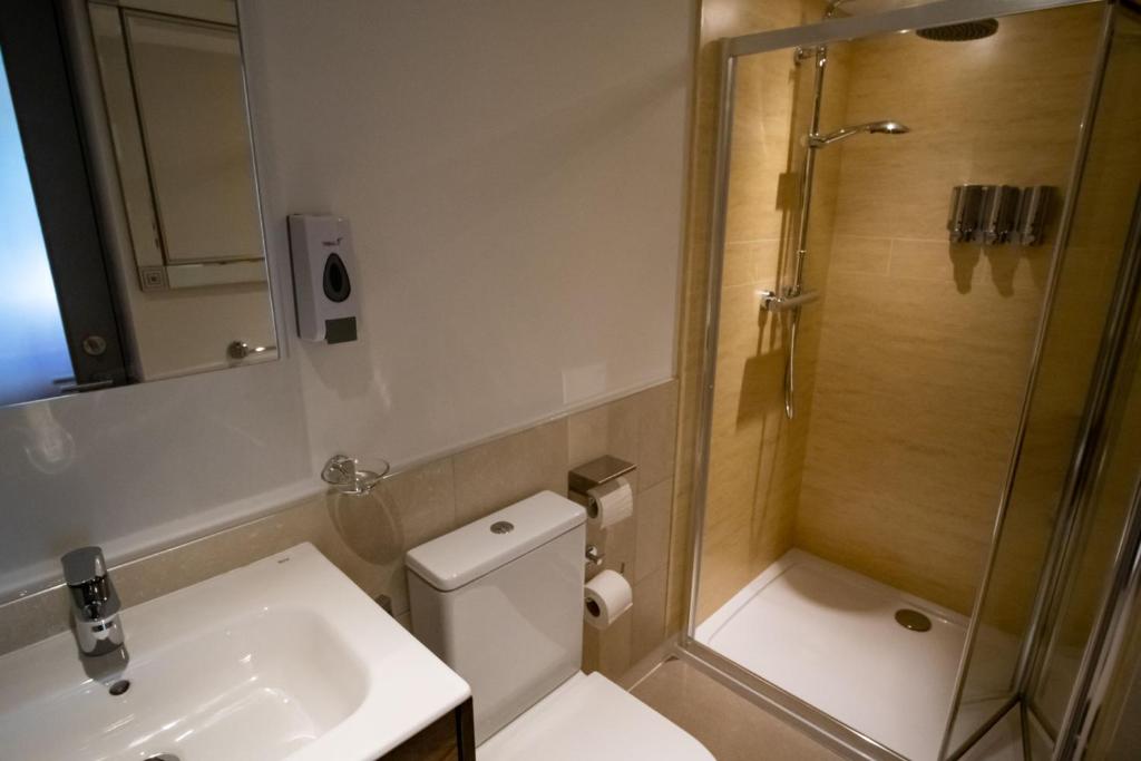 a bathroom with a shower and a toilet and a sink at Magnolia House, Rye in Rye