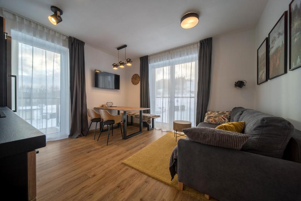 een woonkamer met een bank en een tafel bij Apartmán U Suchého buku - Buková Hora in Červená Voda