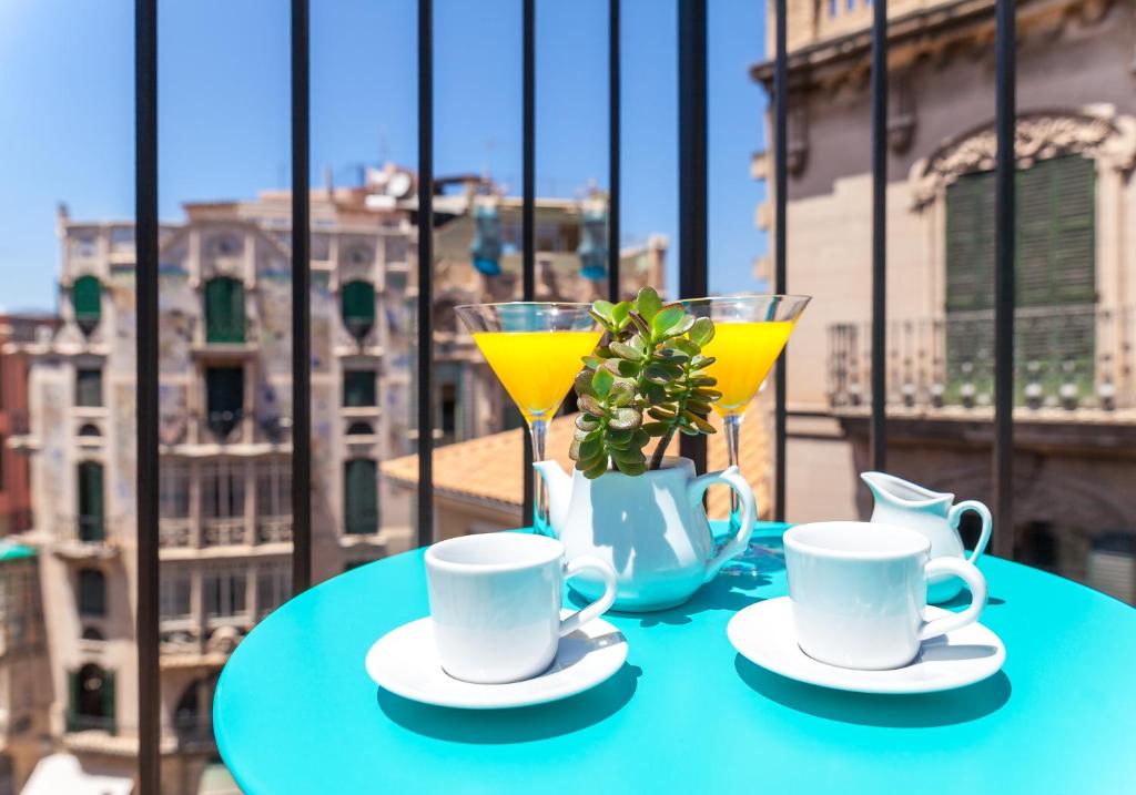 a table with two cups and two glasses on a balcony at Can Boss - Turismo de Interior in Palma de Mallorca