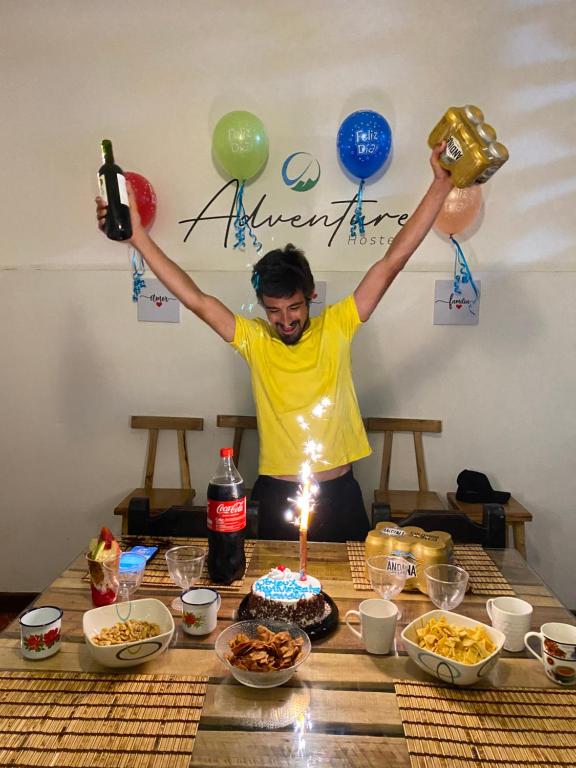 a man standing at a table with a birthday cake at ADVENTURE Hostel in San Gil