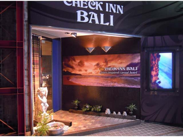 a building with a large sign on the front of it at HOTEL CHECK INN BALI adult only in Tokyo