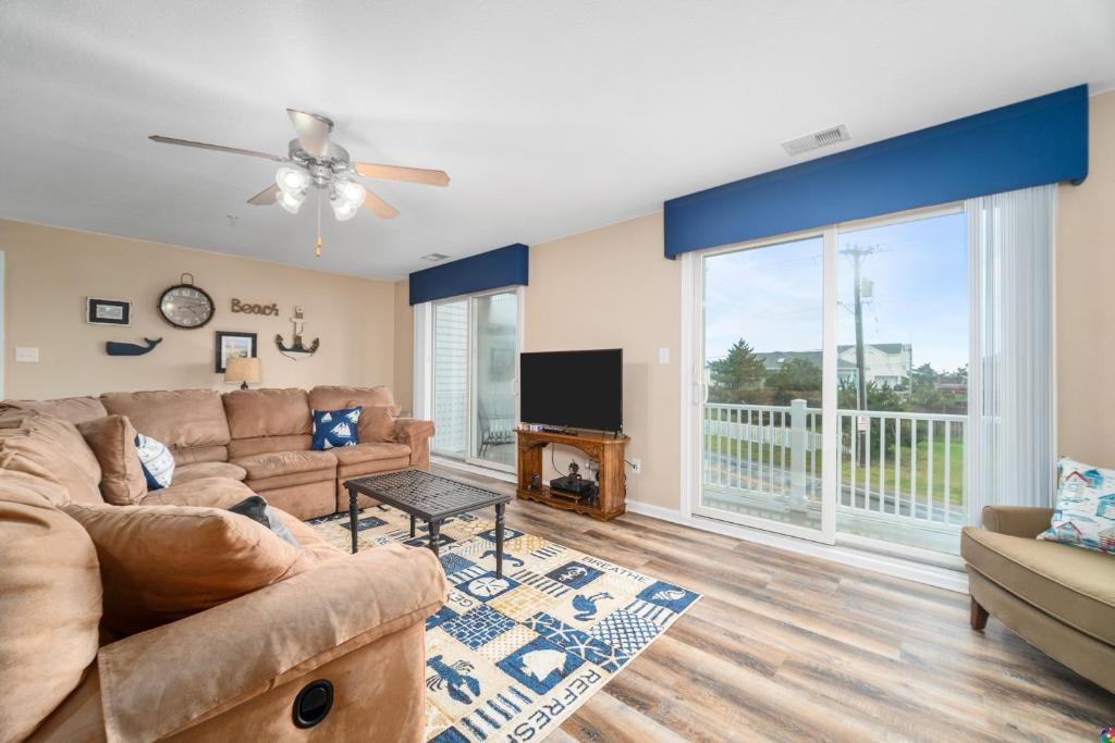 a living room with a couch and a tv at Dolphin's Run 204 DSS in Virginia Beach