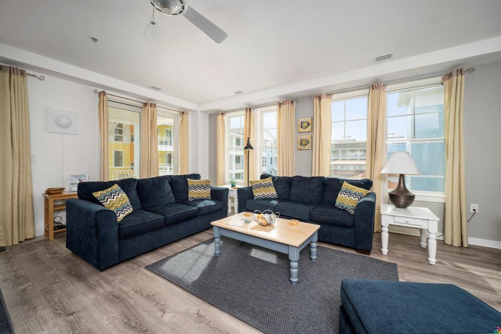 Sala de estar con sofás azules y mesa de centro en The Sanctuary - No Worries 304B en Virginia Beach