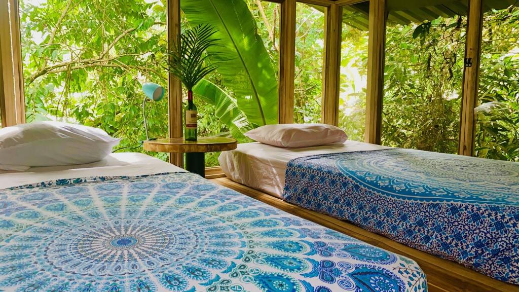 two beds sitting next to each other in a room at Guest House Pura Vida in Quepos