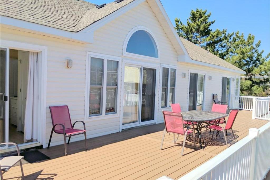 une terrasse avec des chaises roses et une table dans l'établissement Coastal View VI, à Virginia Beach