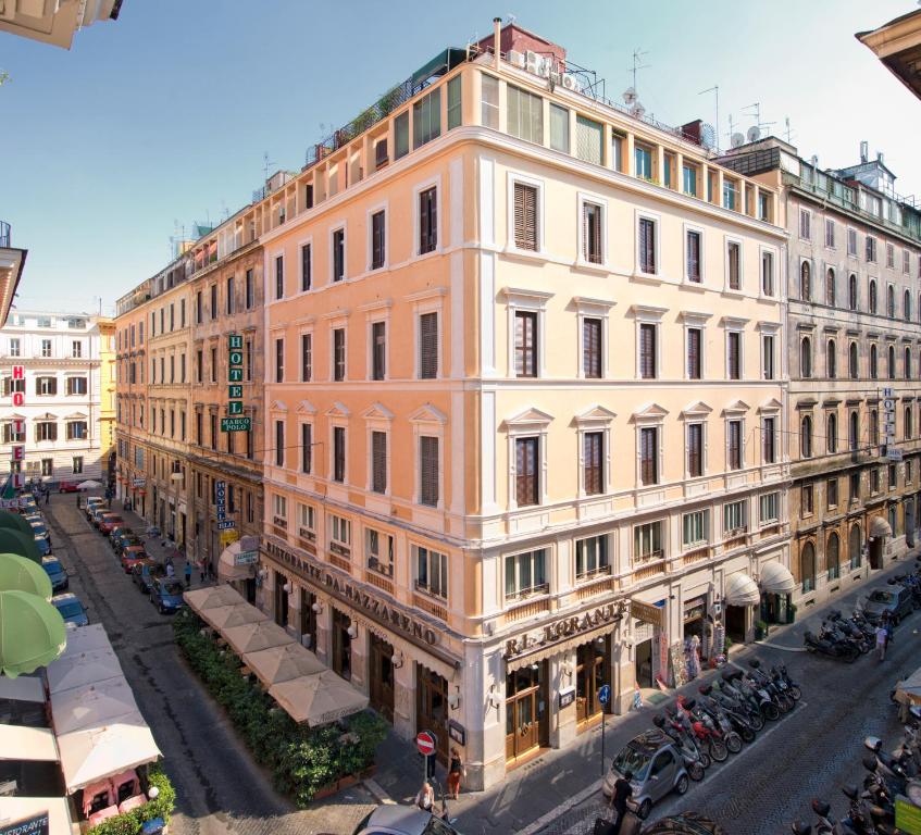 un gran edificio en una calle con coches aparcados en Hotel Marco Polo Rome, en Roma