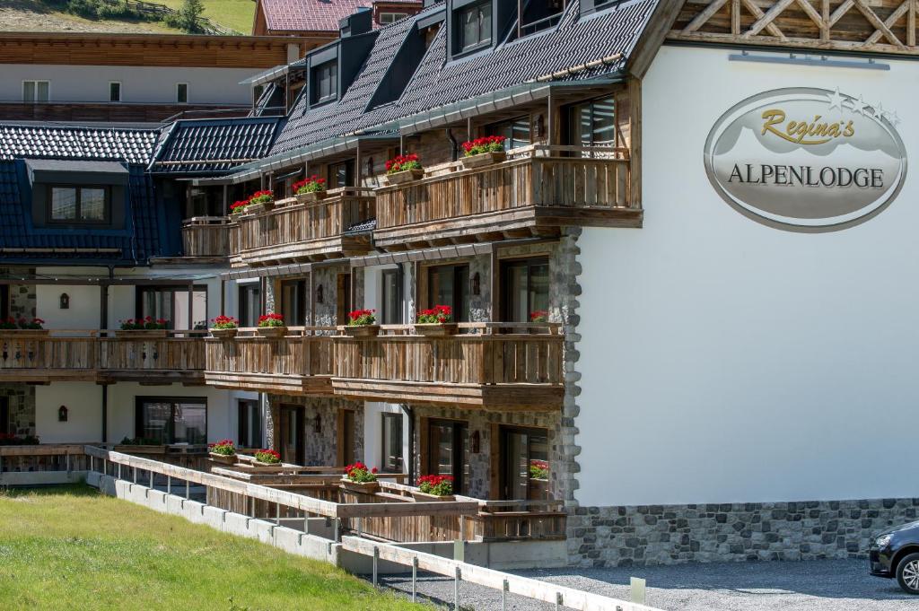 a building with wooden balconies and flowers on it at Regina's Alpenlodge in Sölden