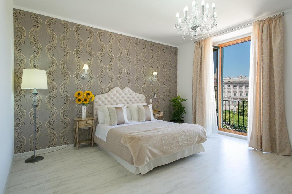 a bedroom with a bed and a large window at Hostal Central Palace Madrid in Madrid