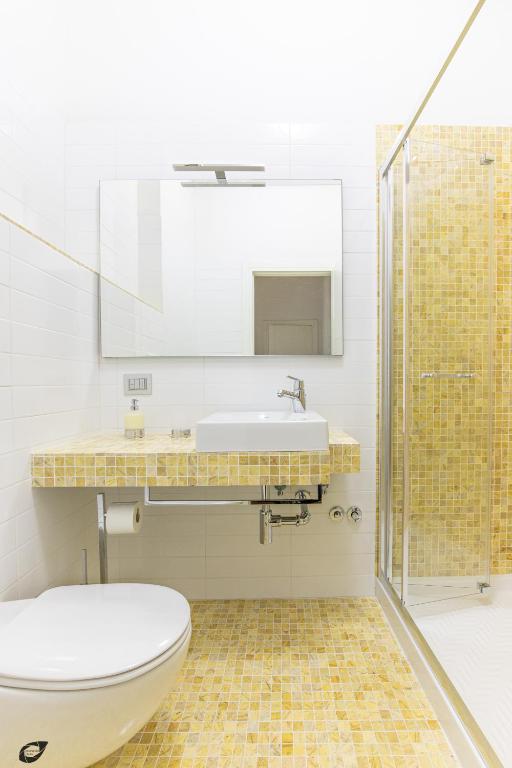 a bathroom with a toilet and a sink and a shower at Elena House Apartments in Viareggio