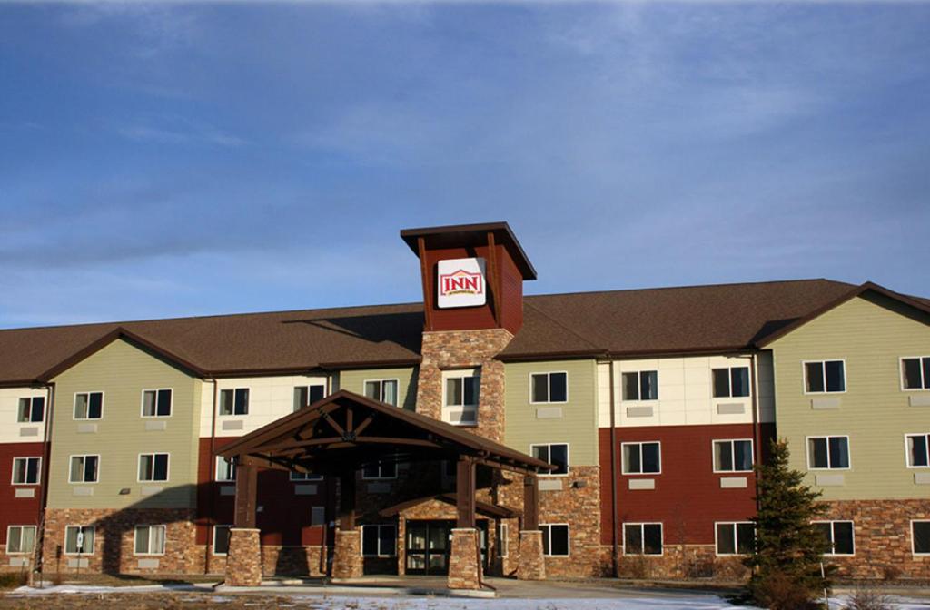 a large building with a clock tower on top of it at Inn at Hunters Run in Watford City