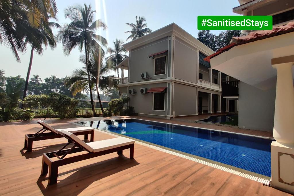 a villa with a swimming pool and a house at The Foothills - A Boutique Hotel in Siolim