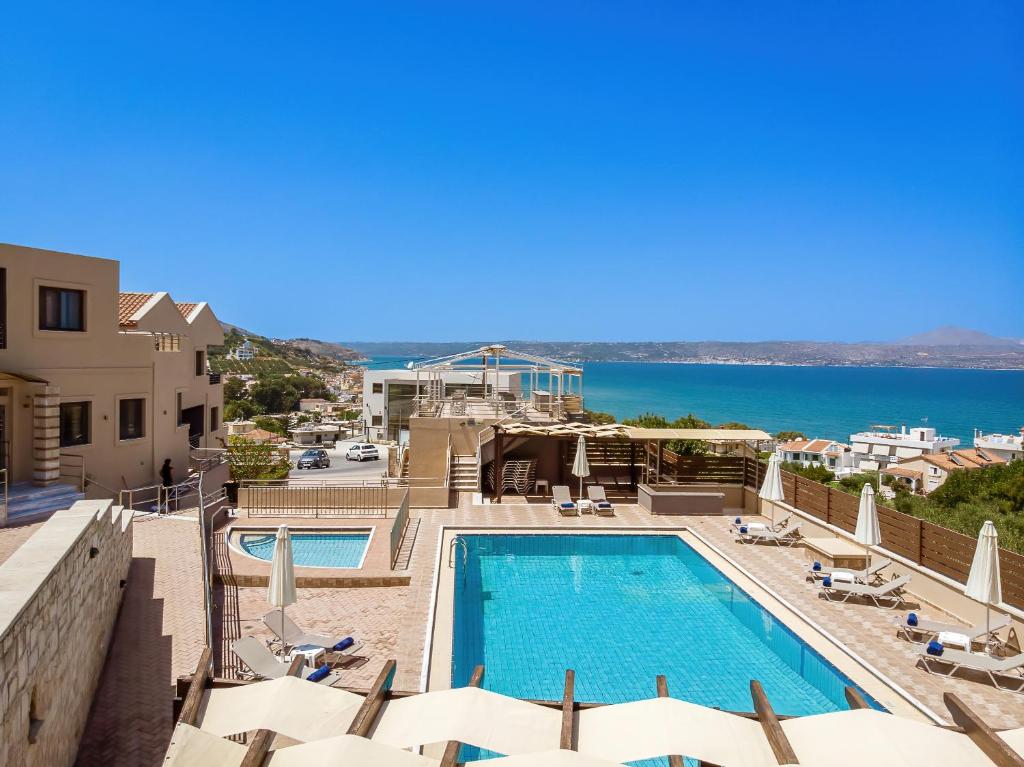 a view of the pool at a resort with the ocean at Sunrise Suites & Apartments in Kalyves