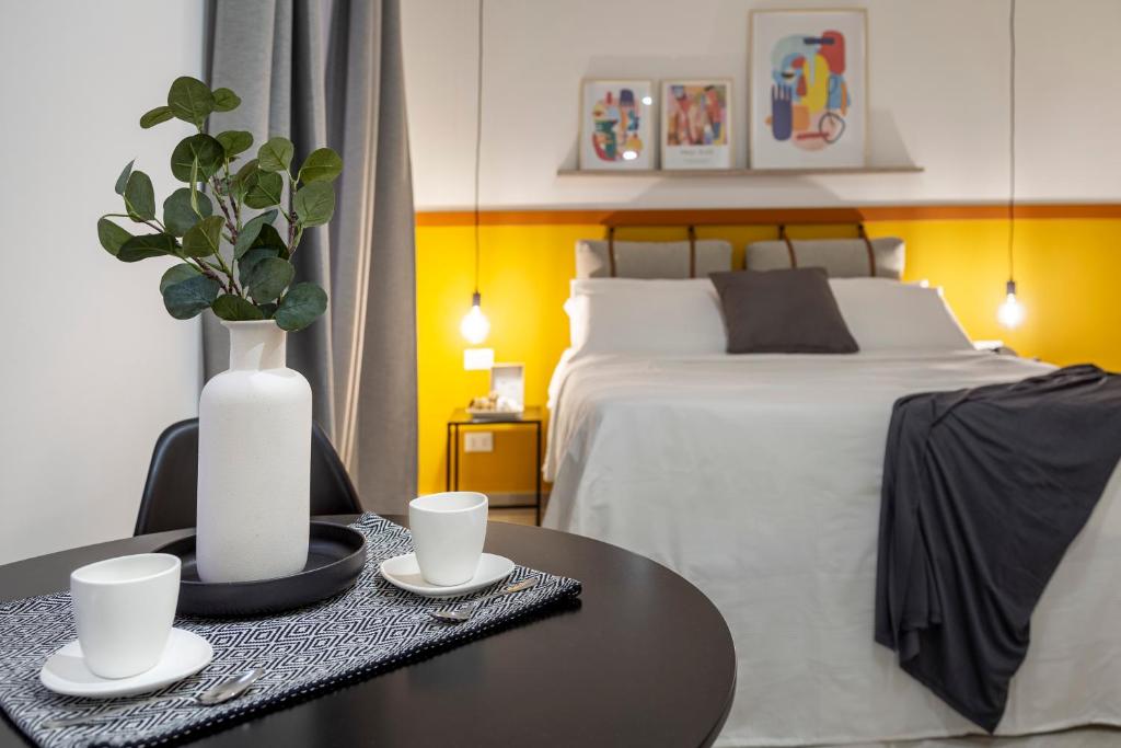 1 dormitorio con 1 cama y 1 mesa con 2 tazas en Lovely nest in the city center Fast WiFi en Trieste