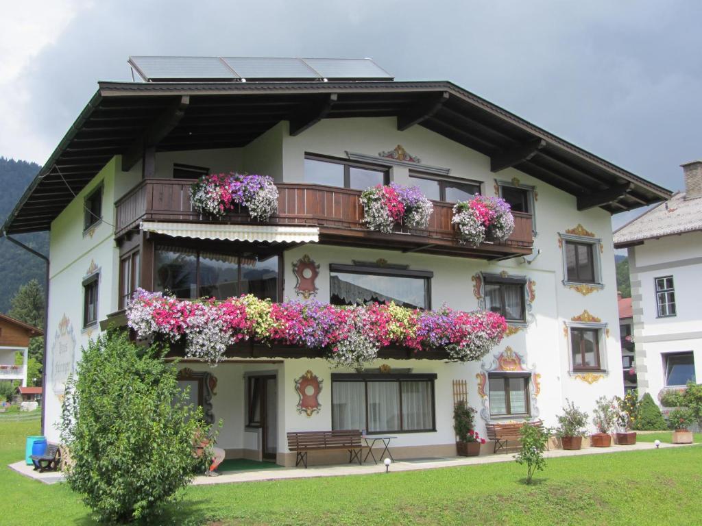 ein Gebäude mit Blumenkästen auf den Balkonen in der Unterkunft Gästehaus Fahringer in Walchsee