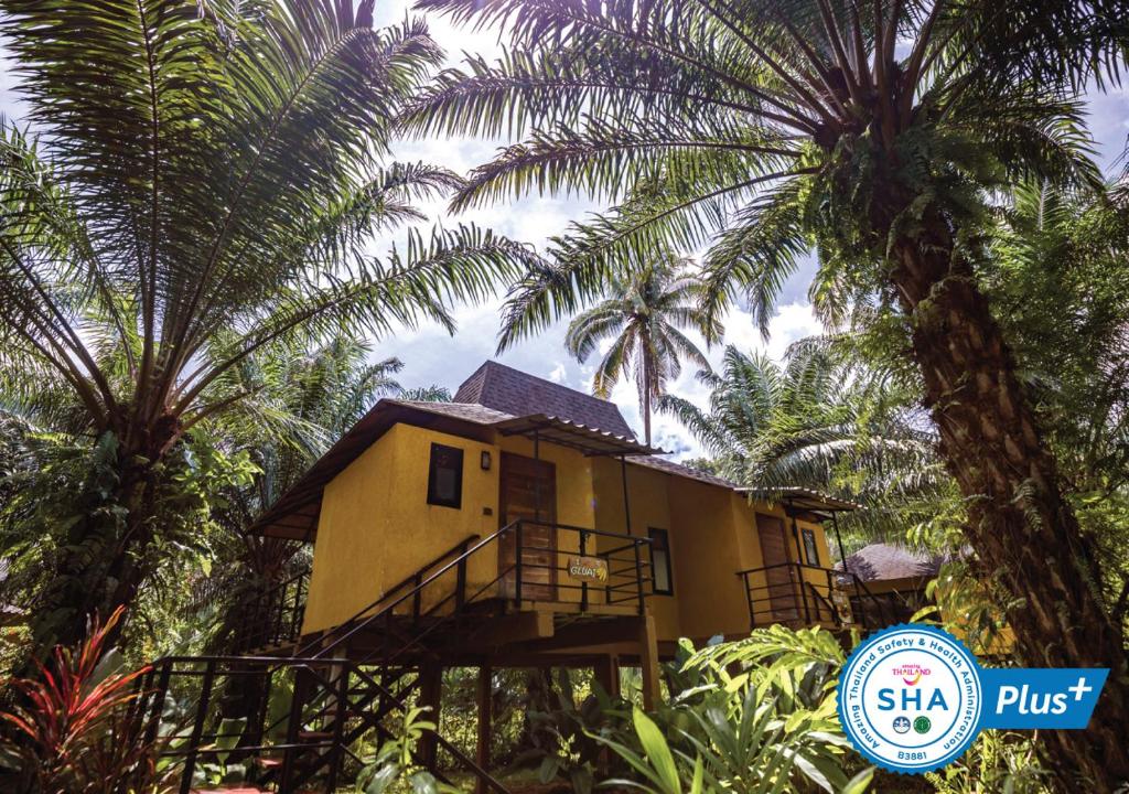 考索的住宿－Anurak Community Lodge - SHA Plus，棕榈树中间的房子