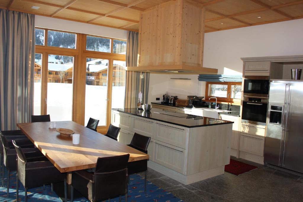 cocina con mesa de madera y cocina con nevera en ClubHotel Hinterthal Am FlorySee 12, en Hinterthal