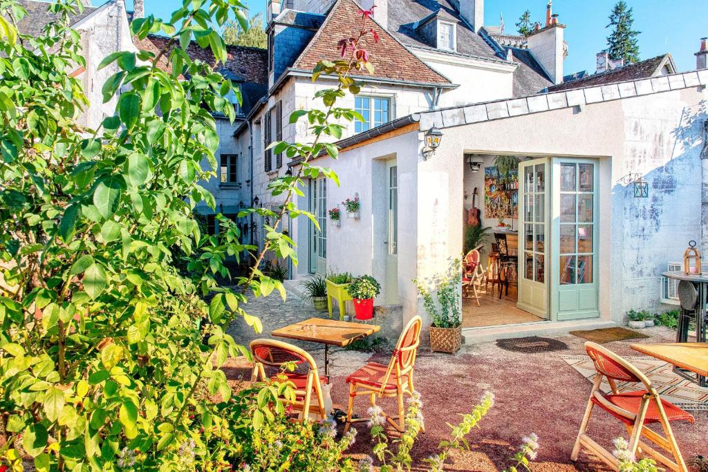 un patio avec une table et des chaises et un bâtiment dans l'établissement La Little Maison, à Loches