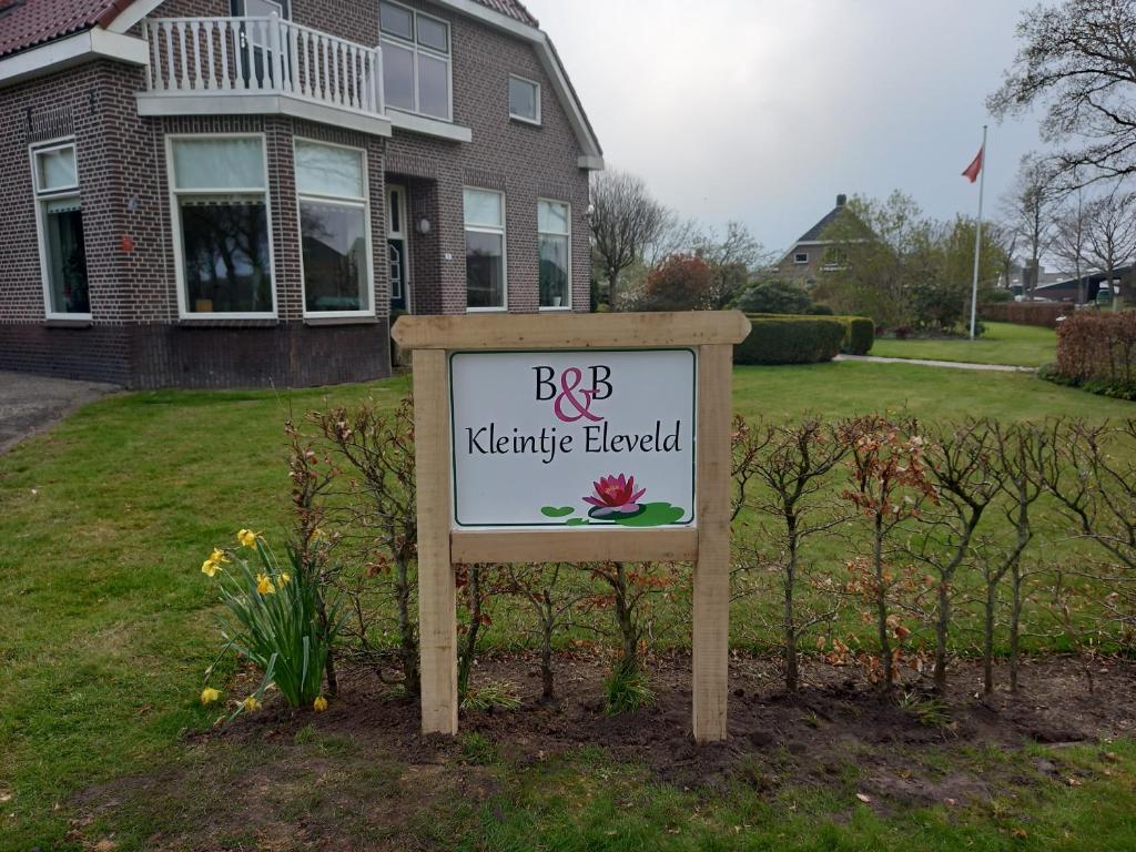 een bord in een tuin voor een huis bij B&B Kleintje Eleveld in Eleveld