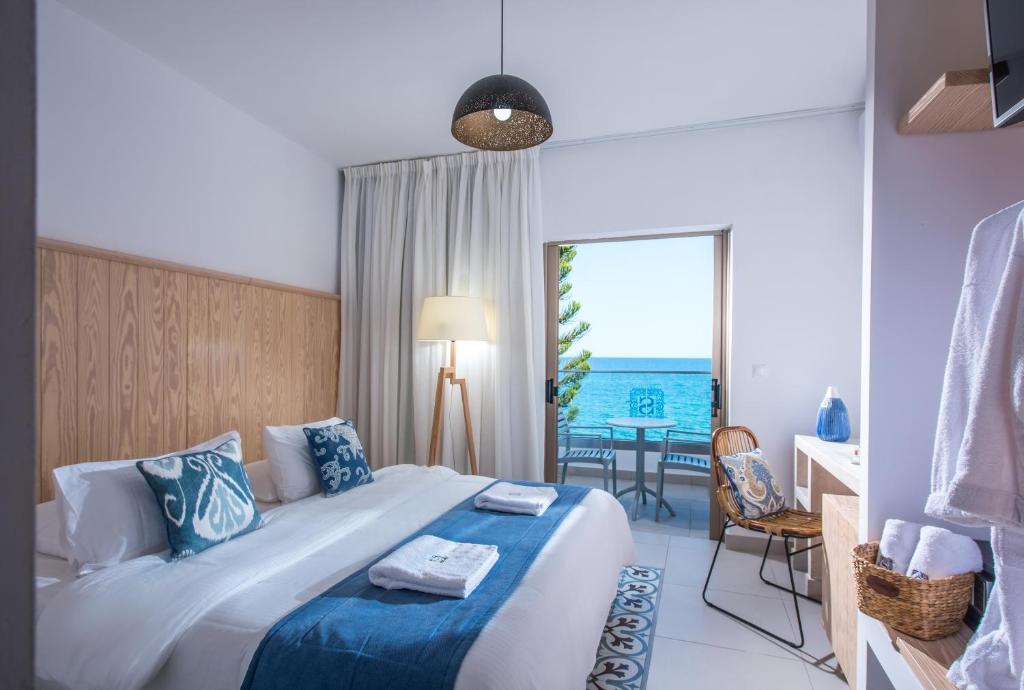 a bedroom with a bed and a view of the ocean at Enorme Serenity Spritz - Adults Only in Hersonissos