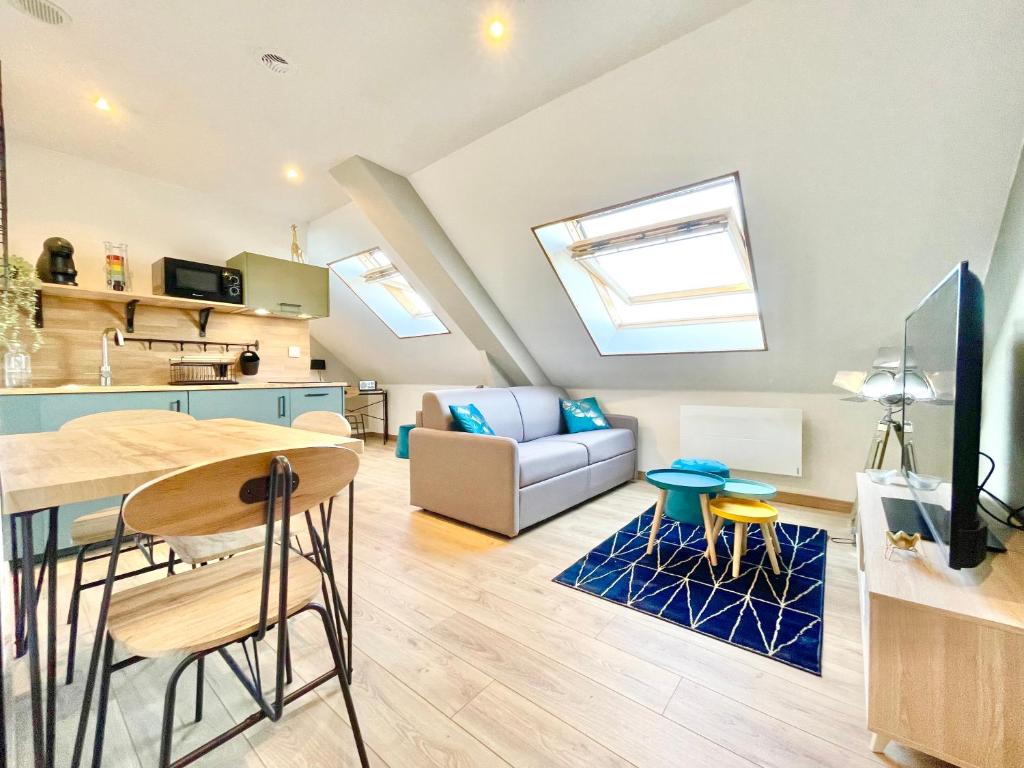 une cuisine et un salon avec une table et des chaises dans l'établissement Saint-Nazaire - LE GLAMOUR - Appartement Deluxe - Stationnement facile et gratuit - Internet Haut Débit Fibre, à Saint-Nazaire