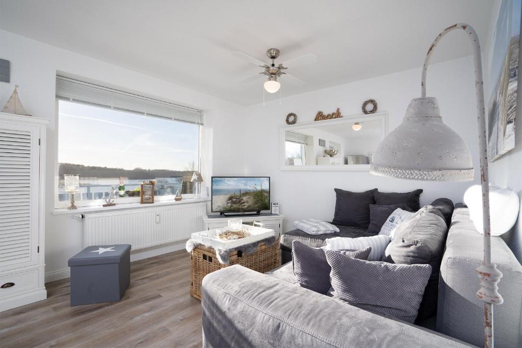 ein Wohnzimmer mit einem Sofa und einem TV in der Unterkunft Haus Sielbeck, Traumblick in Sielbeck