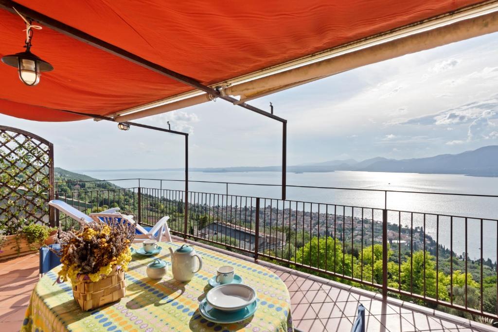 - une table sur un balcon avec vue sur l'eau dans l'établissement Terrazza Torri del Benaco, à Torri del Benaco