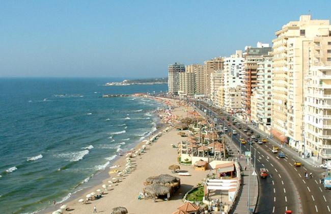 einen Strand mit Gebäuden und dem Meer und einer Stadt in der Unterkunft شقة فندقية اسكندر ابراهيم in Alexandria