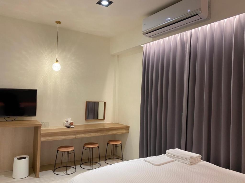 An An Homestay في شينتشنغ: غرفة نوم مع سرير ومكتب مع الكراسي