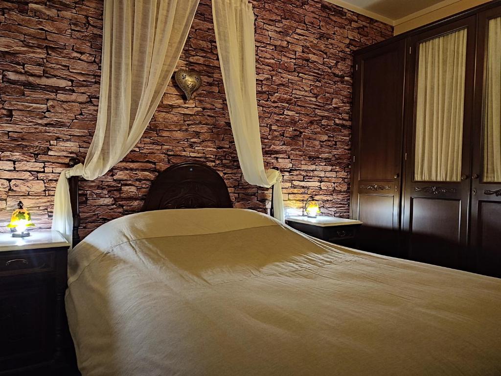 um quarto com uma cama e uma parede de tijolos em British Wood 'n Stone House em Tessalônica