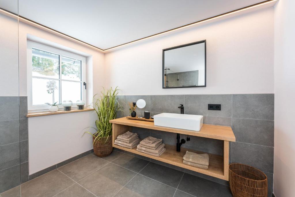 La salle de bains est pourvue d'un lavabo et d'un miroir. dans l'établissement Apartment Schichlreit, à Annaberg-Lungötz