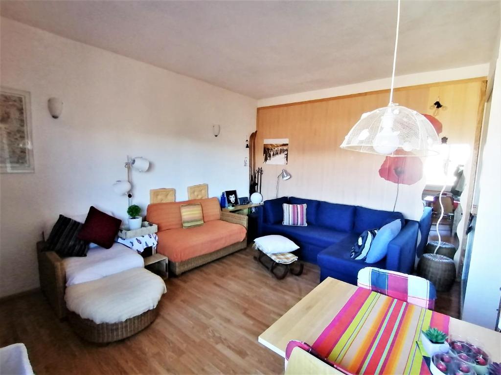 a living room with a blue couch and a chair at Coqueto apartamento en Osseja in Osséja