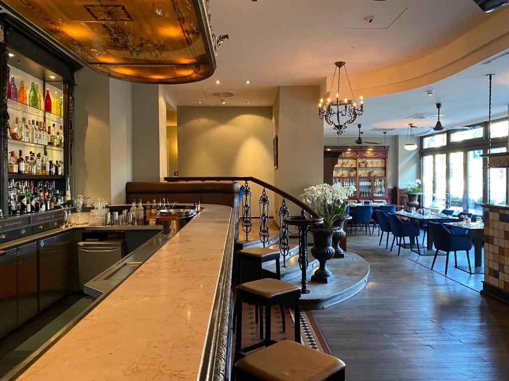 a bar in a restaurant with tables and chairs at Steigenberger Graf Zeppelin in Stuttgart