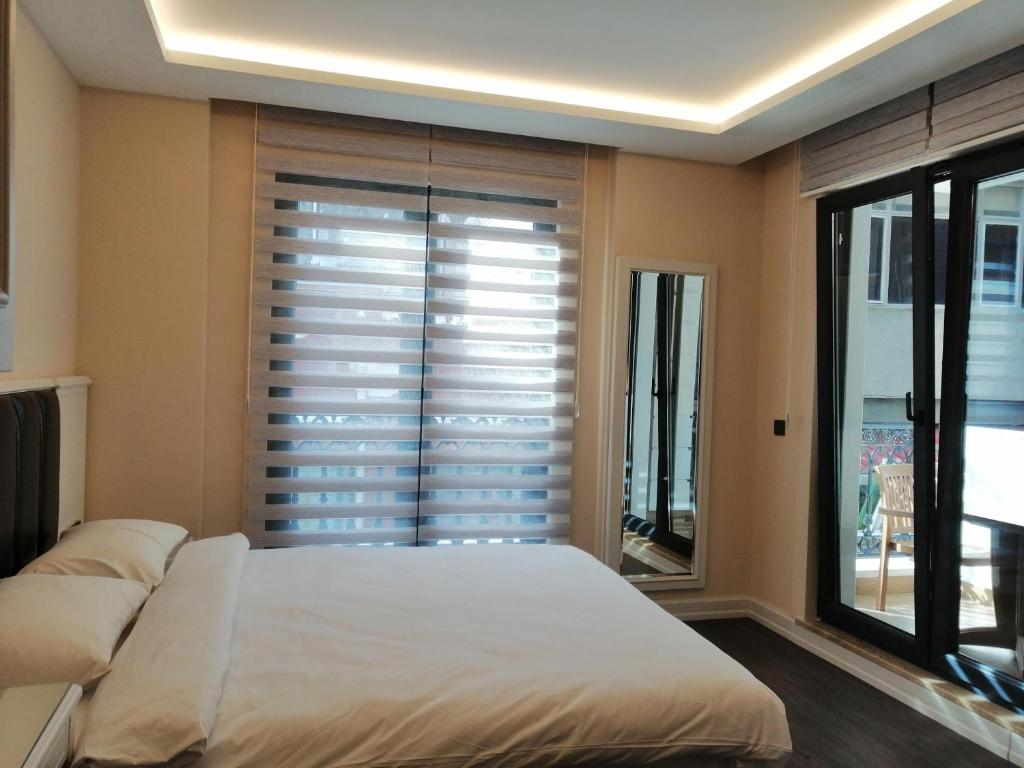 1 dormitorio con 1 cama y ventana con persianas en Opatija Hotel en Estambul