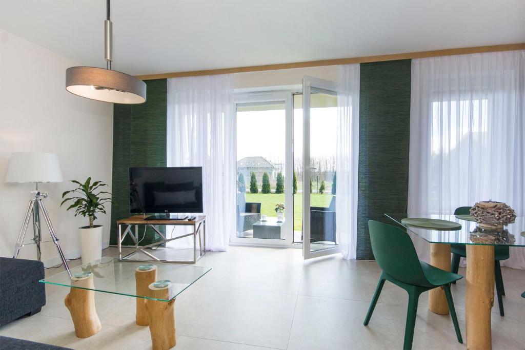 a living room with a glass table and a television at Apartament Zen in Sobieszewo