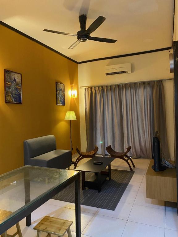 a living room with a couch and a ceiling fan at Aurora @ Morib Gold Coast in Banting