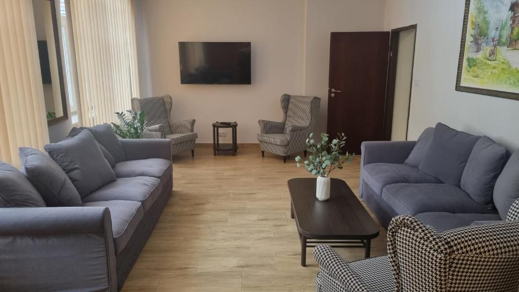uma sala de estar com sofás e cadeiras e uma mesa em HUZAR em Krynica Zdrój