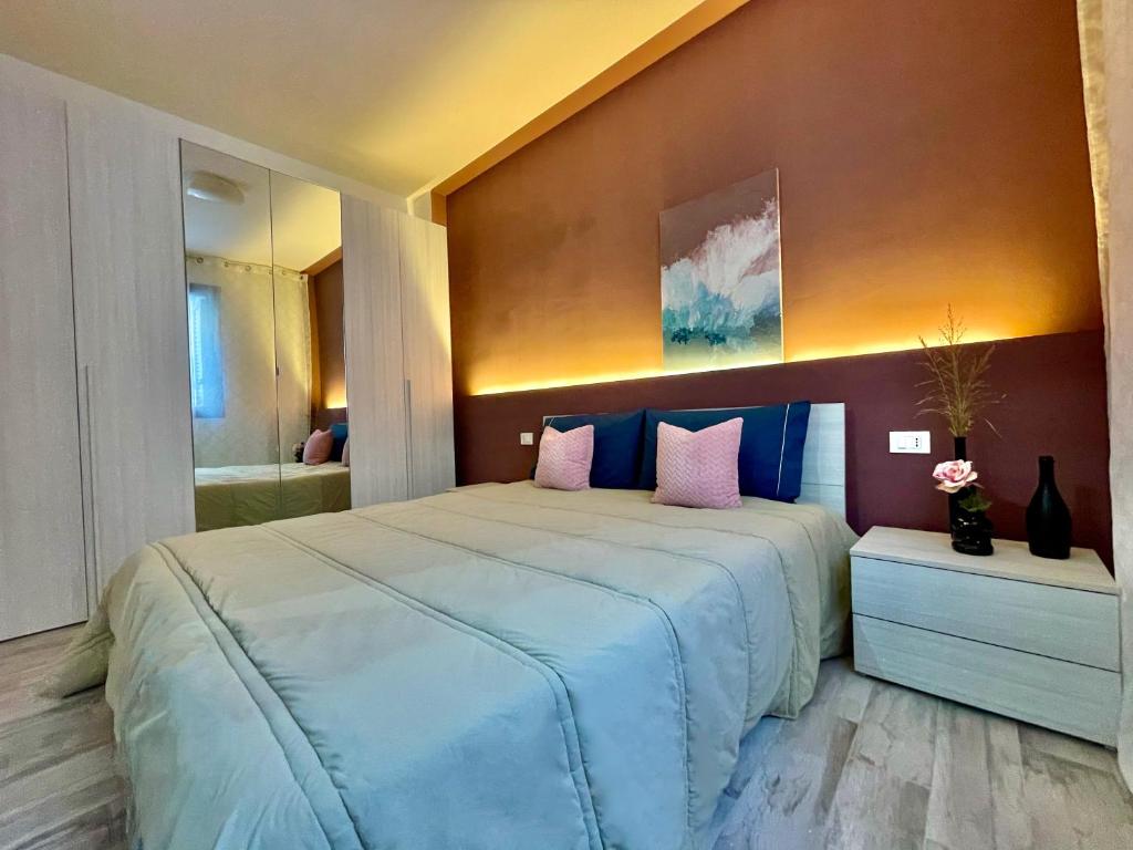 a bedroom with a large bed with pink and blue pillows at Charmrooms in Castellammare del Golfo
