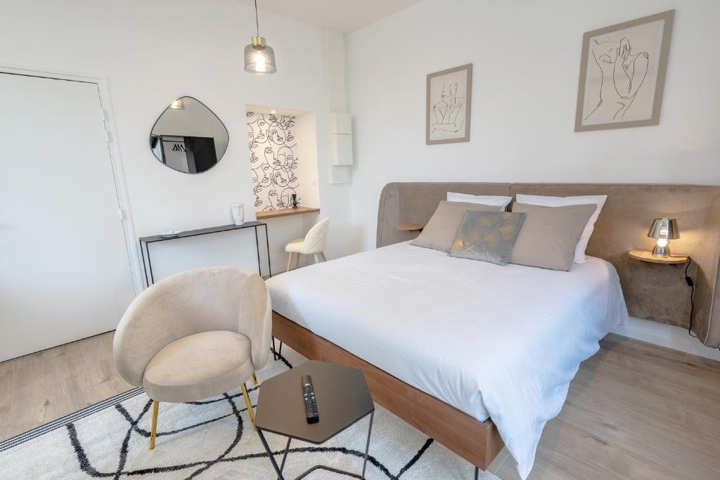 - une chambre avec un lit, une chaise et une table dans l'établissement L'avant-gardiste - Appart'Hotel Le Gatsby, à Saint-Quentin