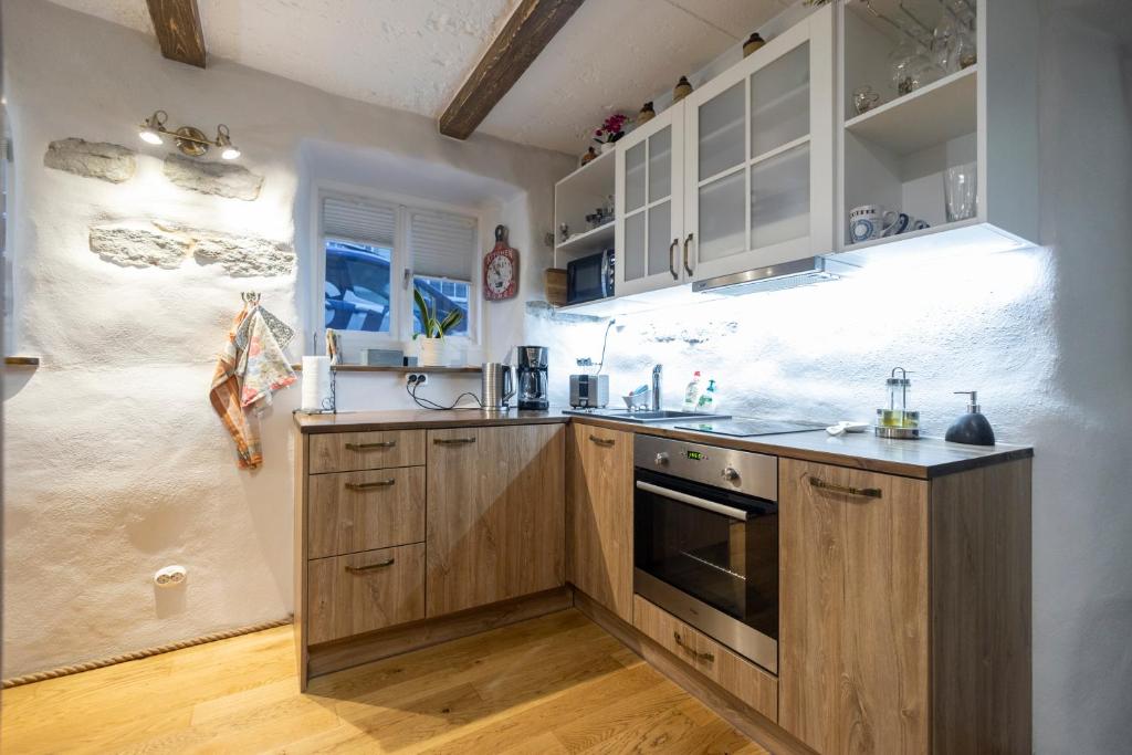 a kitchen with wooden cabinets and a sink at Like Home Apartments Salme 31 in Tallinn