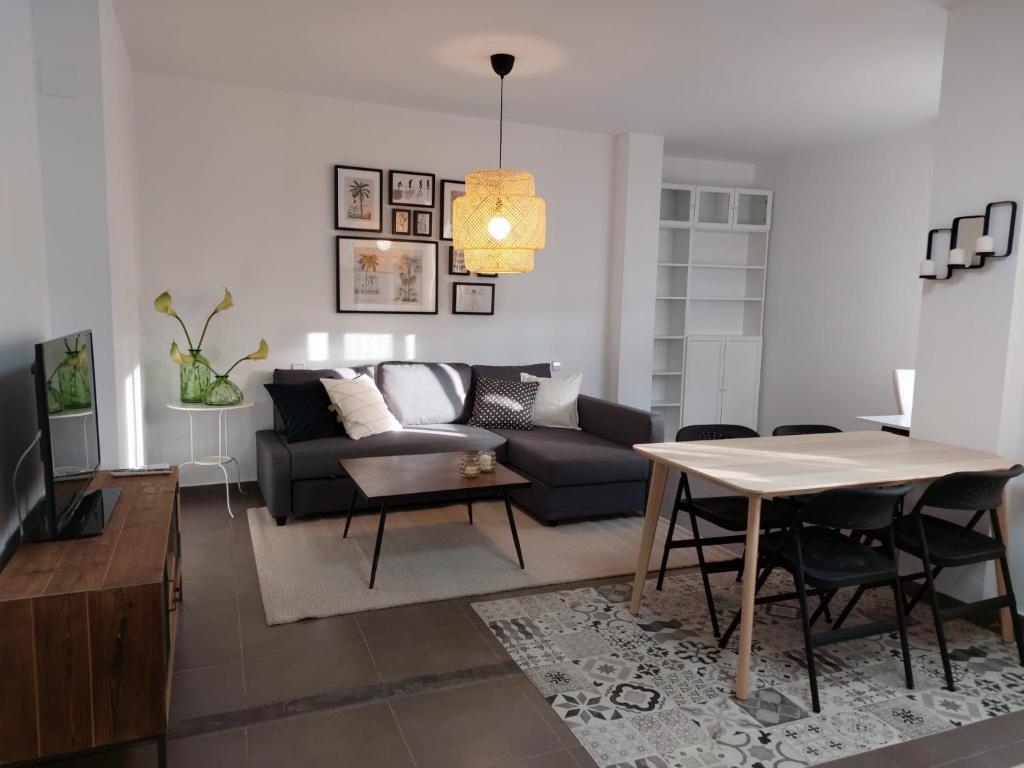 ein Wohnzimmer mit einem Sofa und einem Tisch in der Unterkunft Apartamento JALAMA 1D in Moraleja