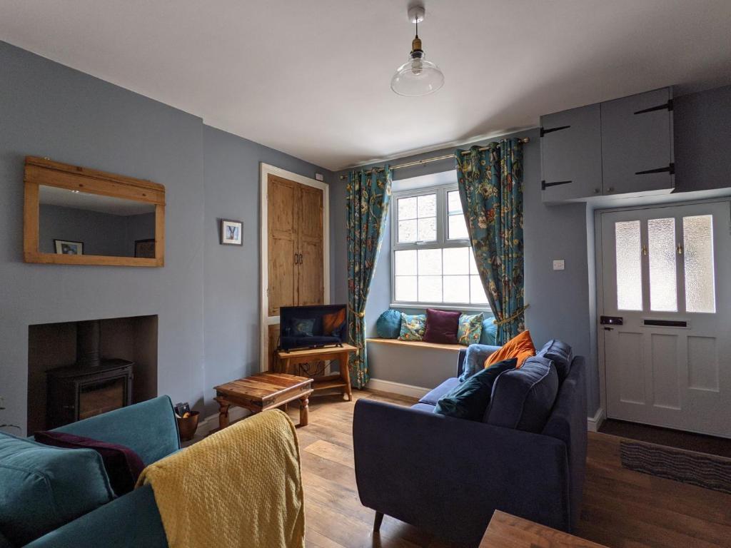 a living room with two couches and a fireplace at Ellers Farm Cottage in Carnforth