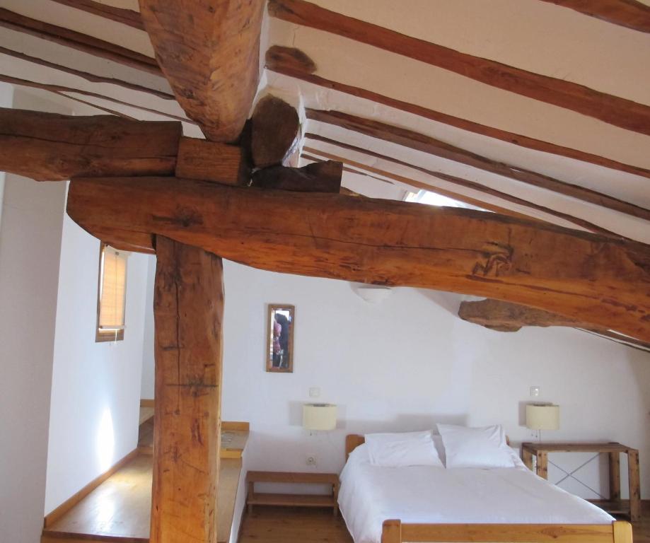 a bedroom with a bed and wooden beams at Casa Barría in Pradoluengo