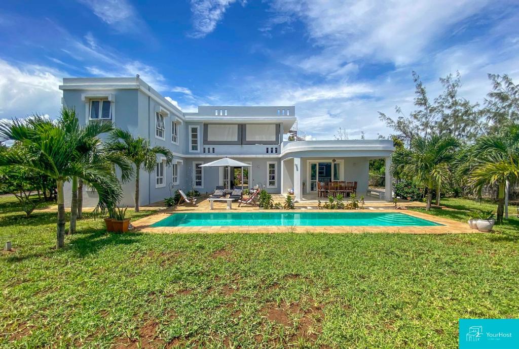 une grande maison avec une piscine dans la cour dans l'établissement Palm Grey Villa By YourHost Vipingo Beach Kilifi, à Kijipwa