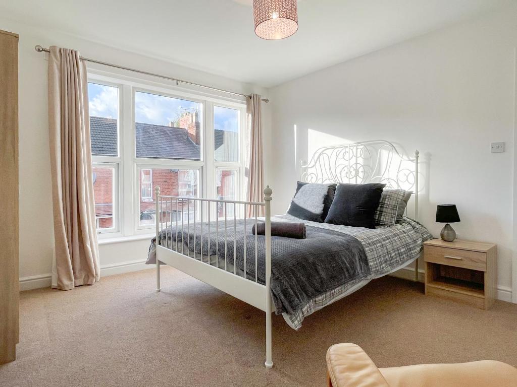 1 dormitorio con cama y ventana en Spacious 2-bed Apartment in Crewe by 53 Degrees Property, ideal for Business & Professionals, FREE Parking - Sleeps 3 en Crewe