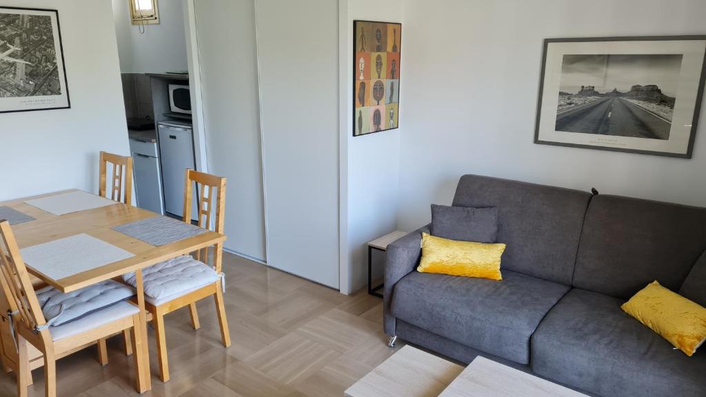 un salon avec un canapé et une table dans l'établissement 2P entièrement climatisé I Bien insonorisé I Wifi I A 300 m de la mer I Restaurants commerces et transports à 5mn à pied I Idéal 2 personnes I Possibilité 4 avec canapé lit de qualité I Très belle Douche, à Cagnes-sur-Mer