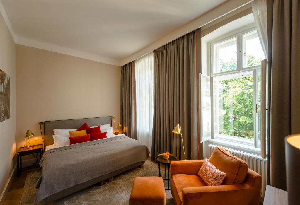 ein Schlafzimmer mit einem Bett, einem Stuhl und einem Fenster in der Unterkunft Roosevelt Stadthaus in Wien