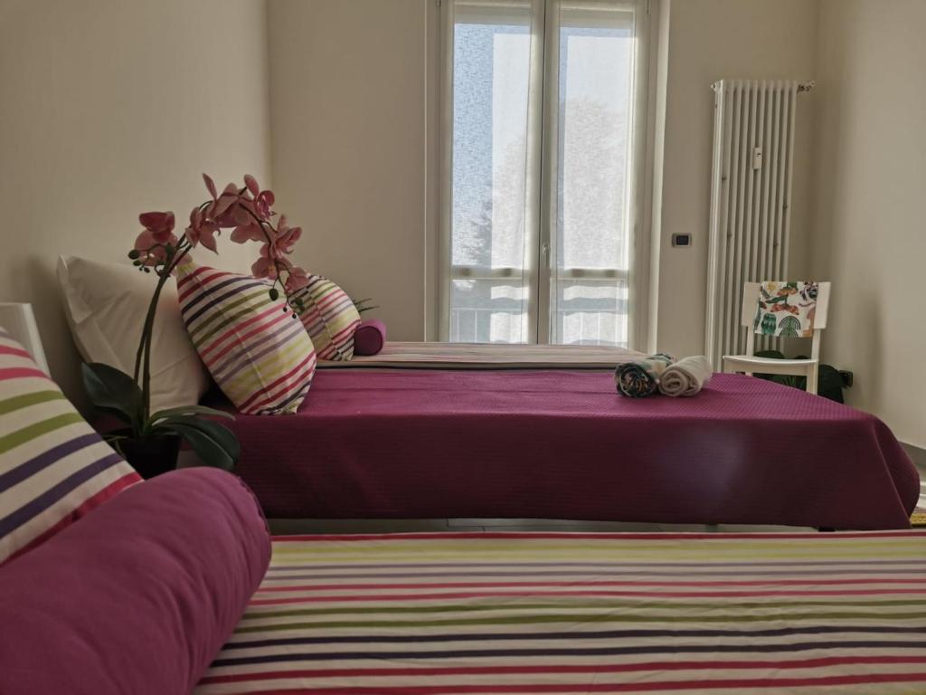 a bedroom with a purple bed and a window at Bnbook Casa Beatrice Appartamento con 2 camere Gallarate in Gallarate
