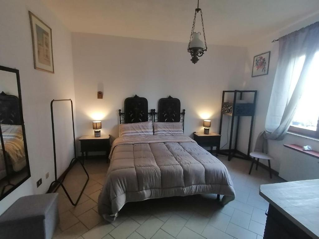 a bedroom with a large bed with two tables and two lamps at Residenza Schinardi in Oristano