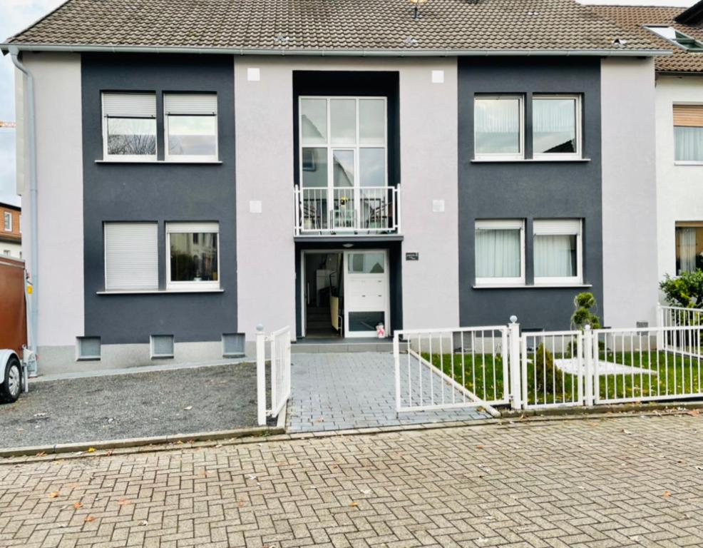 una casa con una cerca blanca delante de ella en Bei Daniel am Dortmunder Flughafen, en Dortmund