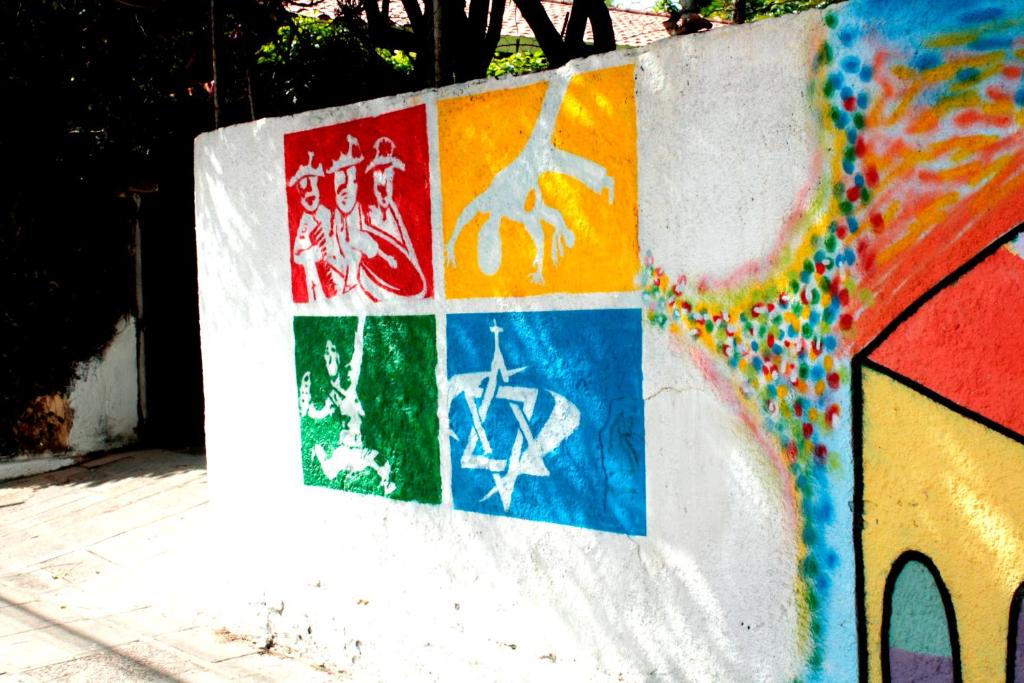 uma parede coberta de graffiti com pinturas nela em Albergue Cultural São Salomão no Recife